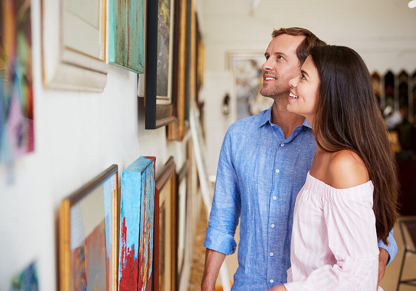 Couple Looking At Paintings In Art Gallery Together